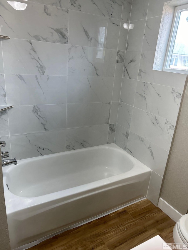 bathroom featuring toilet, bathtub / shower combination, and hardwood / wood-style flooring