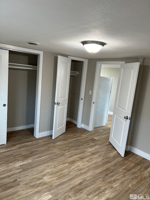 unfurnished bedroom featuring hardwood / wood-style floors and a textured ceiling