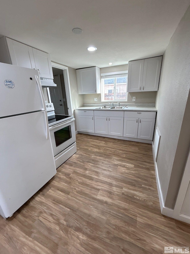 kitchen featuring white appliances, ventilation hood, sink, white cabinets, and light hardwood / wood-style floors