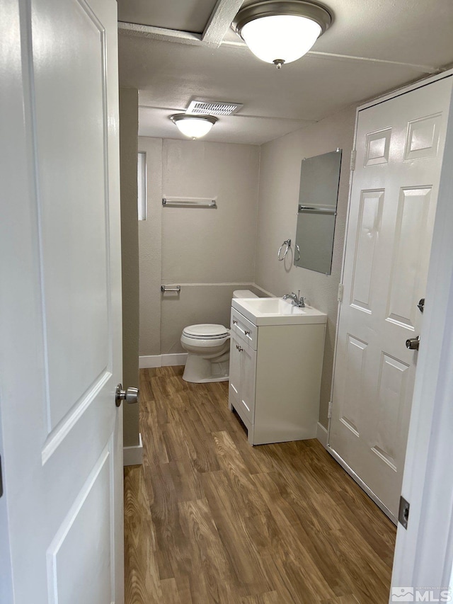 bathroom with vanity, hardwood / wood-style flooring, and toilet