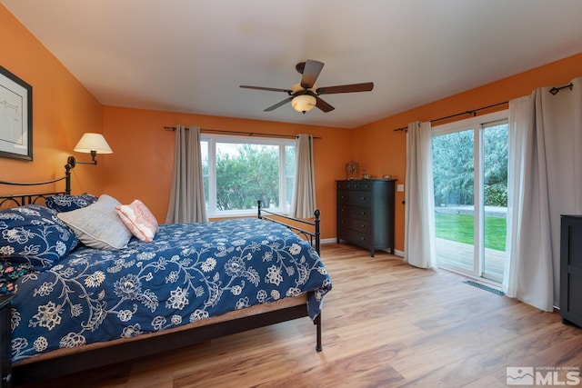 bedroom with access to exterior, hardwood / wood-style floors, and ceiling fan