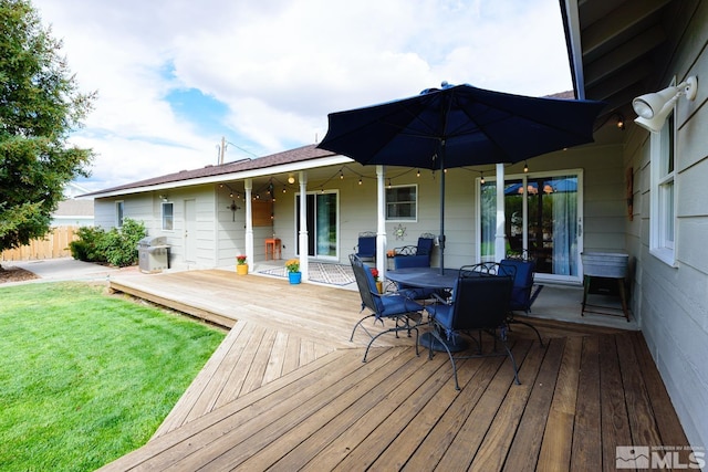 wooden deck with a yard and grilling area