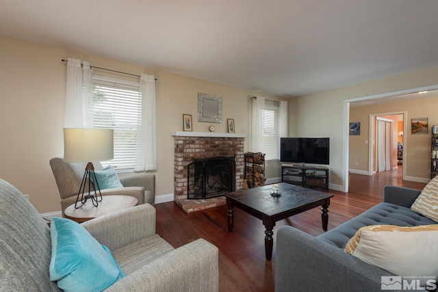 living room featuring dark hardwood / wood-style floors and a brick fireplace