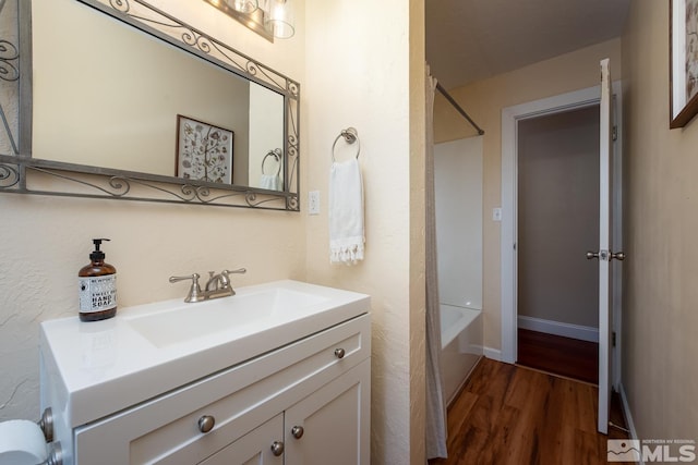 bathroom featuring hardwood / wood-style floors, vanity, and shower / bathing tub combination