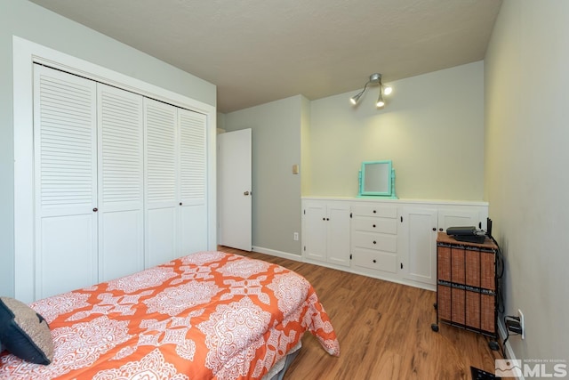 bedroom with light hardwood / wood-style floors and a closet