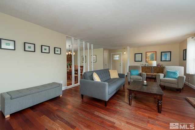 living room with dark hardwood / wood-style floors and an inviting chandelier