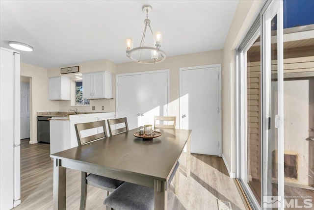 dining space featuring an inviting chandelier and light hardwood / wood-style flooring