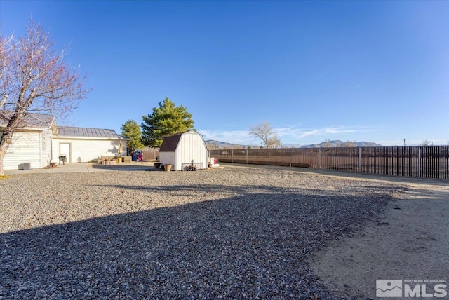 view of yard featuring a mountain view and a storage unit