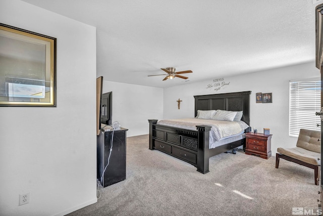 bedroom with a textured ceiling, light colored carpet, and ceiling fan