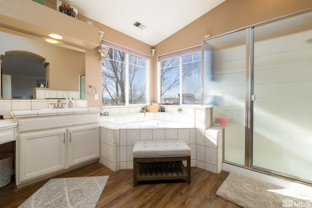 bathroom with hardwood / wood-style flooring, vanity, lofted ceiling, and independent shower and bath