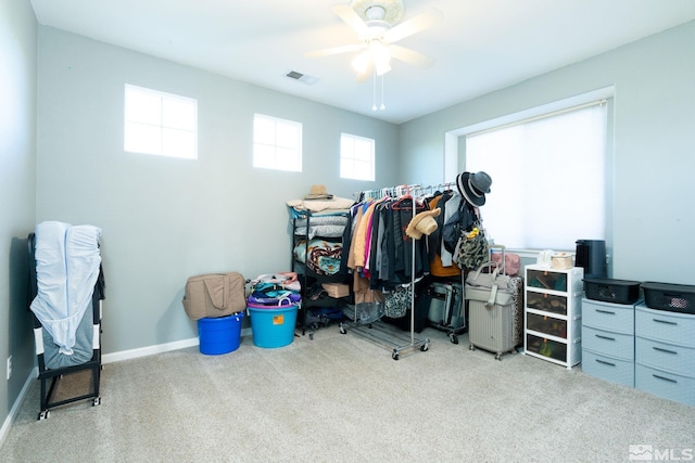 spacious closet with ceiling fan and light colored carpet