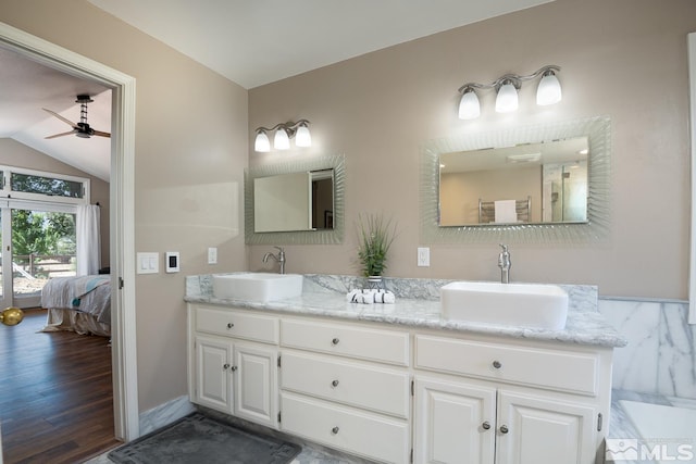 bathroom with ceiling fan, hardwood / wood-style floors, vanity, and vaulted ceiling