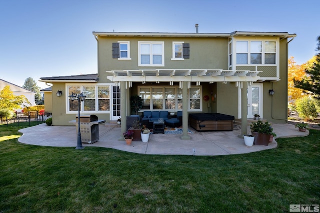 rear view of property featuring a yard, a pergola, a hot tub, and a patio area