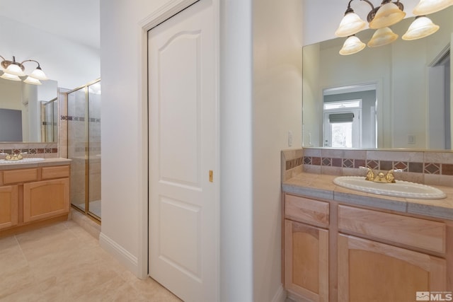 bathroom with vanity, walk in shower, and tasteful backsplash