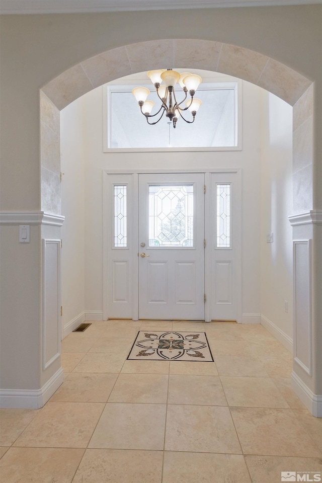 tiled entrance foyer with an inviting chandelier