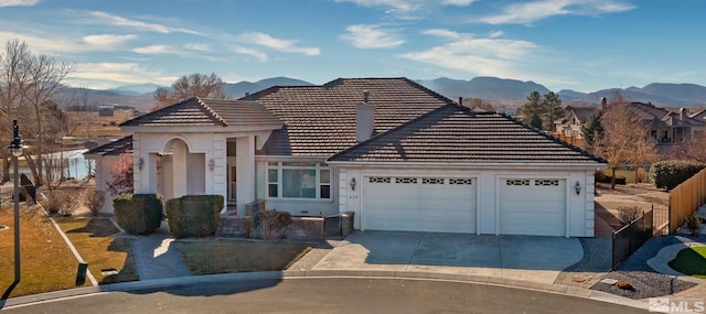 view of front of home with a mountain view and a garage