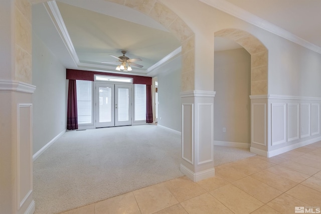 empty room featuring light carpet, french doors, ceiling fan, and crown molding