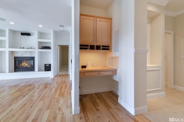 kitchen with light brown cabinetry, built in features, and light hardwood / wood-style floors