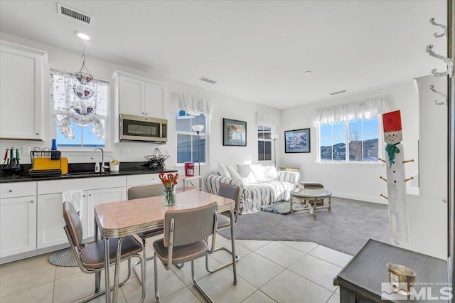 dining space with light tile patterned floors and sink