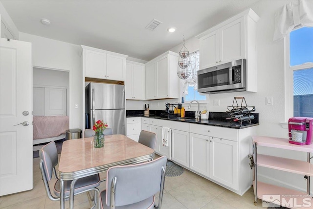 kitchen featuring white cabinetry, plenty of natural light, stainless steel appliances, and sink