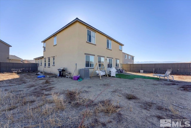 rear view of property with central AC