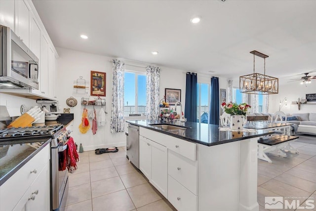 kitchen with white cabinetry, sink, an island with sink, pendant lighting, and appliances with stainless steel finishes