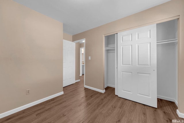 unfurnished bedroom featuring light hardwood / wood-style flooring and a closet