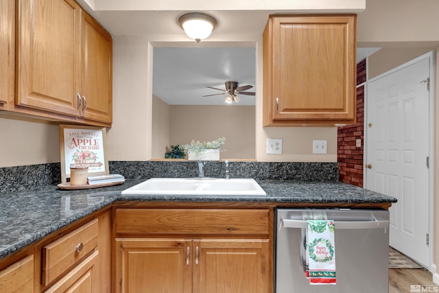 kitchen with ceiling fan, sink, stainless steel dishwasher, dark stone counters, and light hardwood / wood-style floors