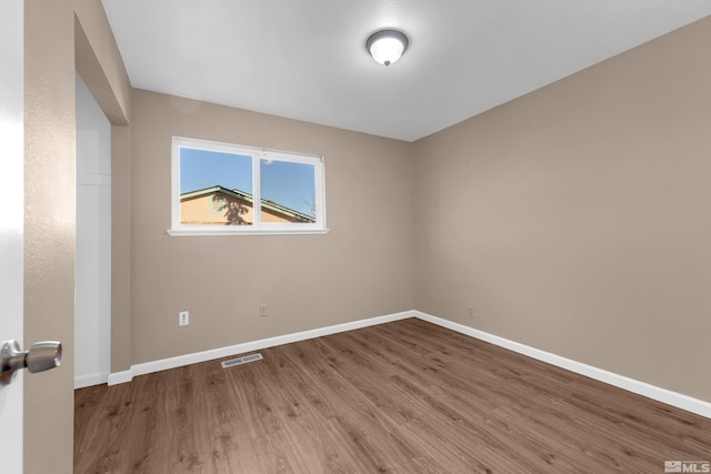 spare room featuring wood-type flooring