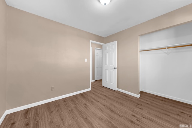 unfurnished bedroom featuring a closet and hardwood / wood-style flooring