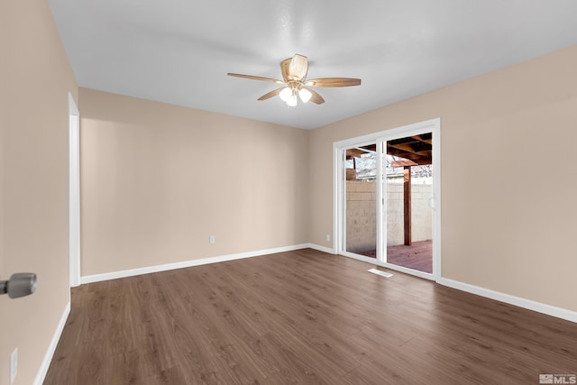 spare room with dark hardwood / wood-style flooring and ceiling fan