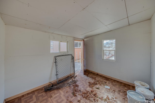 spare room featuring parquet floors and plenty of natural light