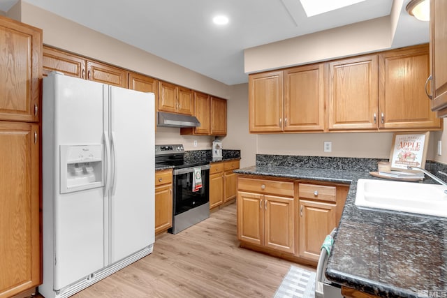 kitchen featuring a skylight, electric range, white fridge with ice dispenser, sink, and light hardwood / wood-style floors