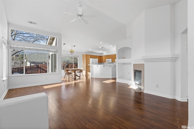 unfurnished living room with a fireplace, dark hardwood / wood-style floors, high vaulted ceiling, and ceiling fan