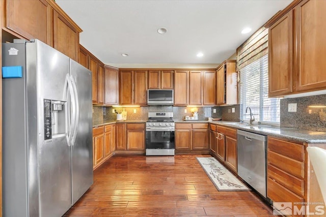 kitchen featuring tasteful backsplash, dark hardwood / wood-style flooring, stainless steel appliances, and sink