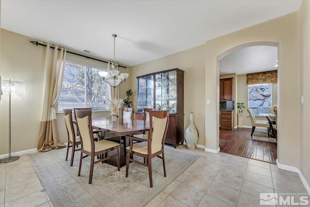 dining space featuring a notable chandelier and light tile patterned floors