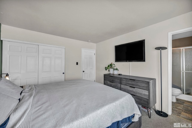 bedroom with ensuite bath, a closet, and dark colored carpet