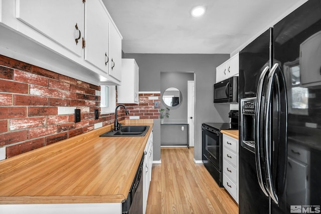 kitchen with white cabinetry, sink, black appliances, and light wood-type flooring