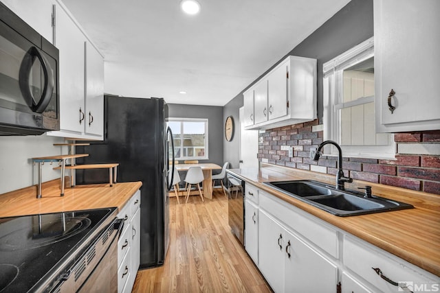 kitchen with white cabinetry, sink, and light hardwood / wood-style flooring