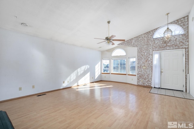 entrance foyer with ceiling fan, high vaulted ceiling, and light hardwood / wood-style floors