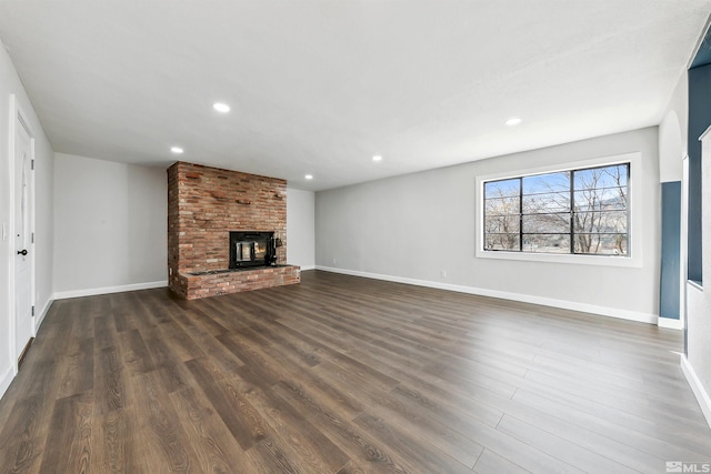 unfurnished living room with a fireplace and dark wood-type flooring