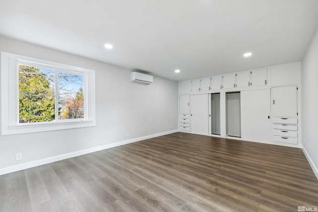 spare room with hardwood / wood-style flooring and a wall mounted air conditioner