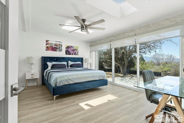 bedroom with hardwood / wood-style floors, ceiling fan, and access to outside