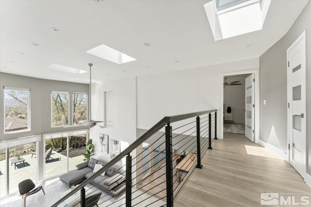 corridor featuring a skylight and light wood-type flooring