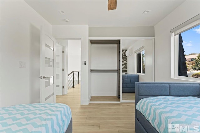 bedroom with ceiling fan, a closet, and light hardwood / wood-style flooring