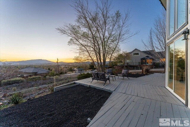 deck at dusk featuring a mountain view