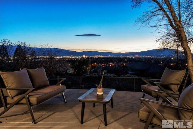 patio terrace at dusk featuring a deck with mountain view and outdoor lounge area