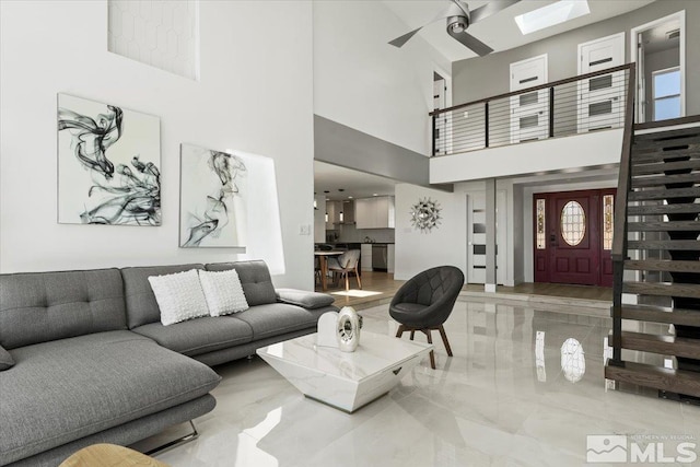 living room with ceiling fan and a high ceiling