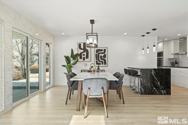 dining room featuring light wood-type flooring and a notable chandelier