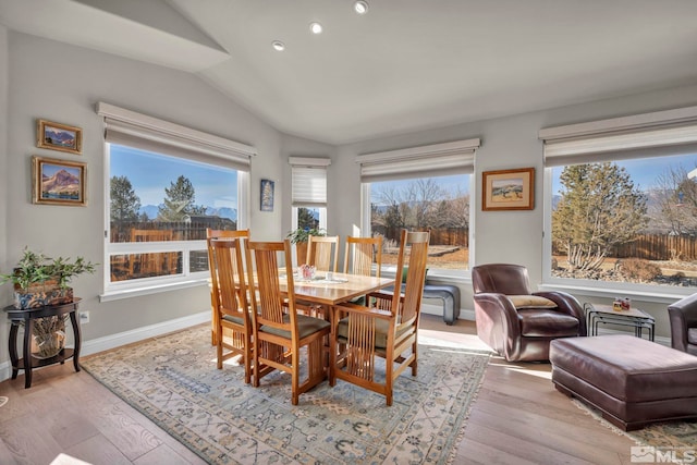 dining space featuring light hardwood / wood-style floors and vaulted ceiling